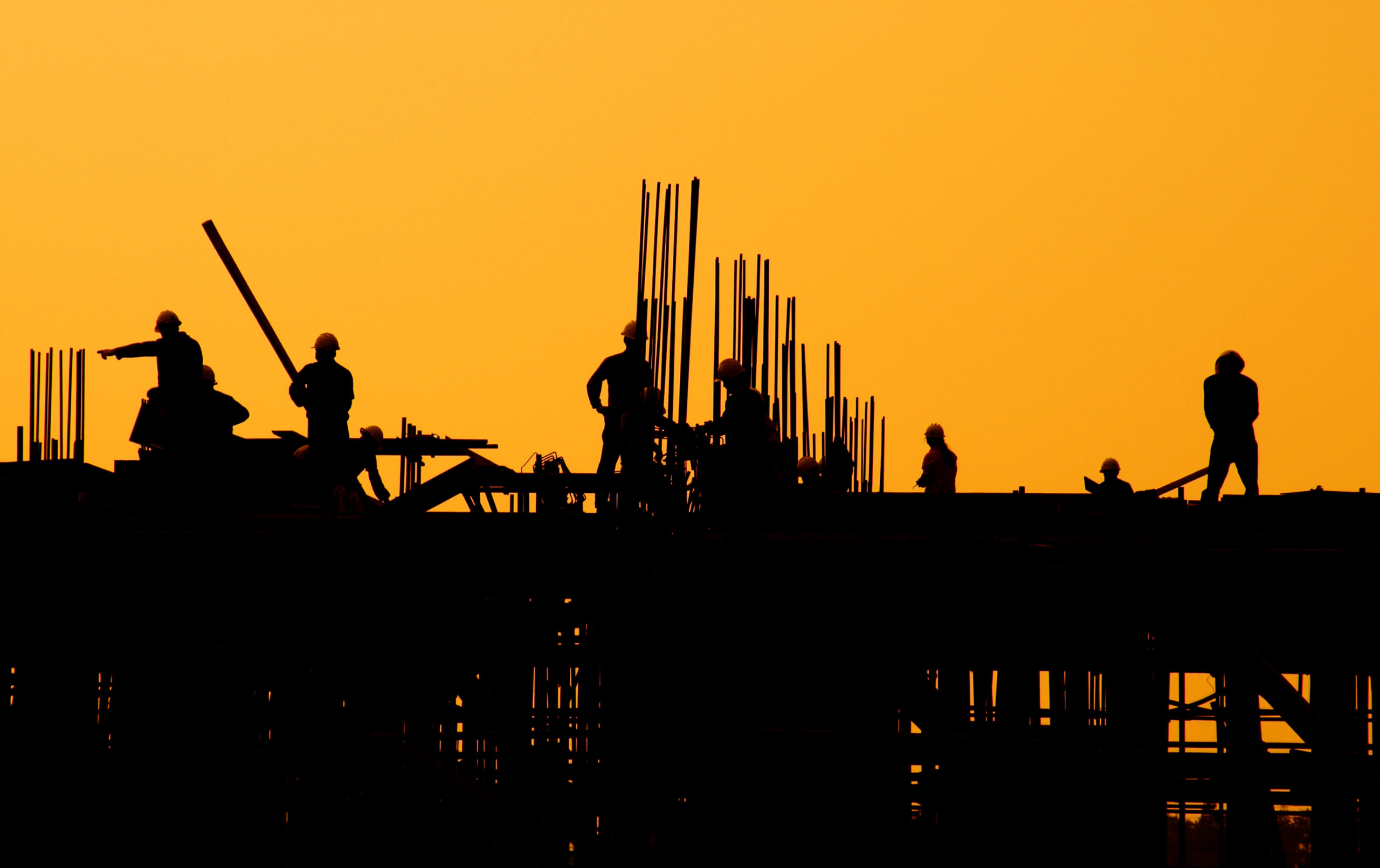 Construction workers at sunset